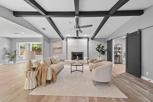 a living room with furniture a fireplace and a chandelier