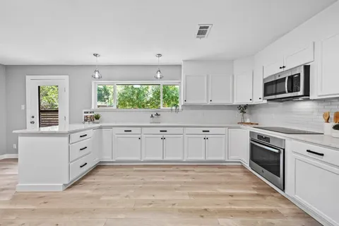 a kitchen with white cabinets and white appliances