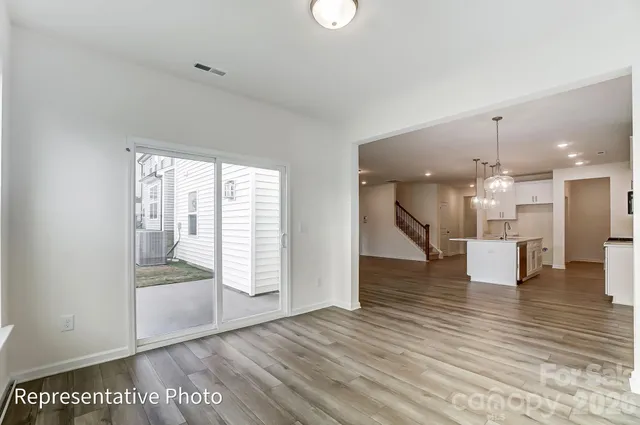 a view of an empty room with wooden floor and a cabinet
