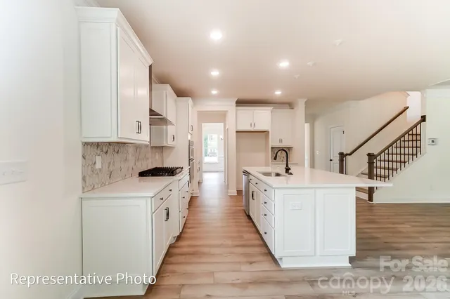 a kitchen with white cabinets appliances and sink