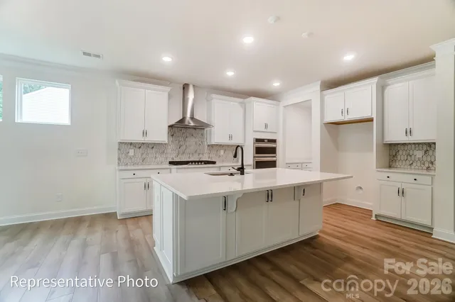a large kitchen with kitchen island a sink stainless steel appliances and cabinets