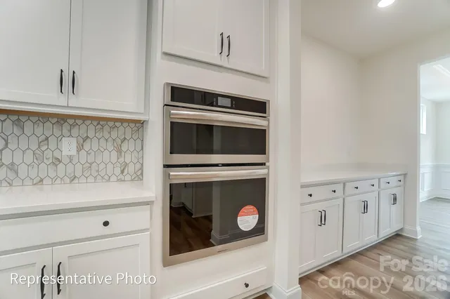a kitchen with granite countertop white cabinets white stainless steel appliances and sink