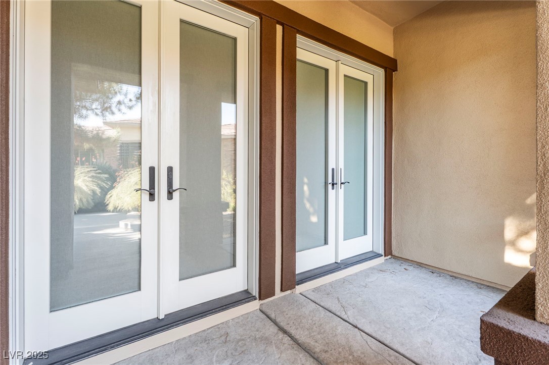 11280 Granite Ridge Drive, Unit 1037 Las Vegas, NV 89135 - Photo 43 of 62 French doors lead to the living room from the front patio. All French doors have full length shades