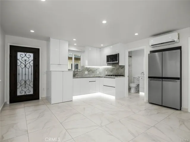 a kitchen with stainless steel appliances granite countertop a refrigerator and a stove top oven
