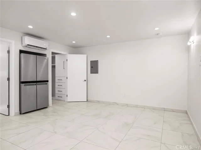 an empty room with kitchen view and window