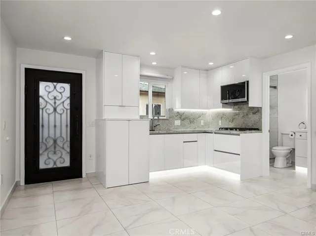 a kitchen with stainless steel appliances granite countertop a refrigerator and a stove top oven