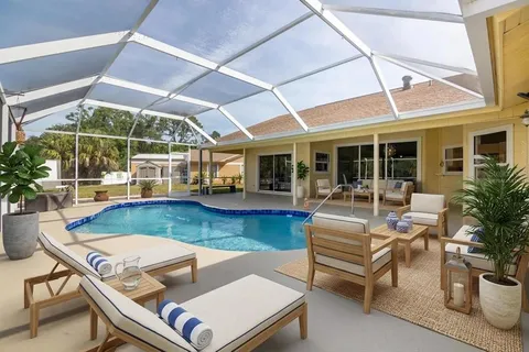 a view of a patio with couches table and chairs under an umbrella