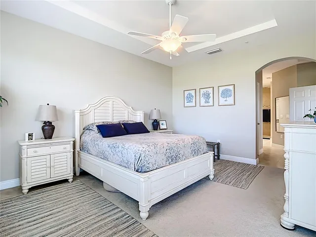 a bedroom with a large bed and a chandelier