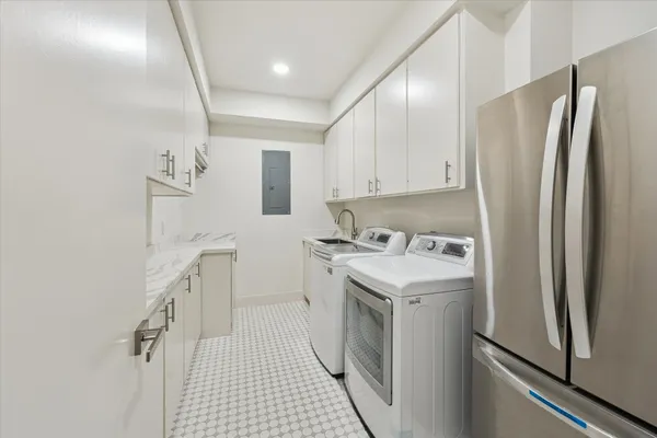 a utility room with cabinets washer and dryer