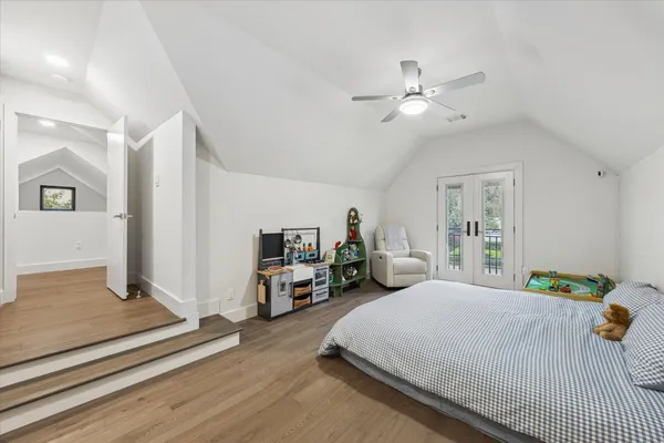 a bedroom with a bed gym equipment and view of living room