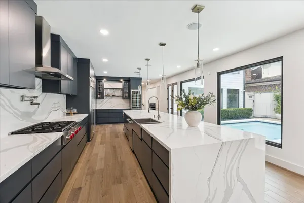 a kitchen with stainless steel appliances a sink stove and wooden floor