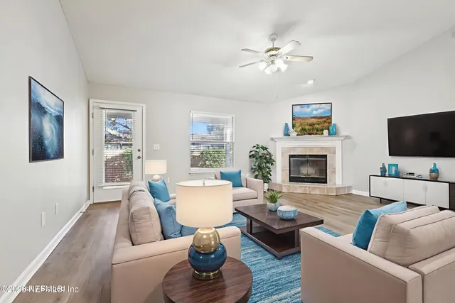 a living room with furniture a flat screen tv and a fireplace