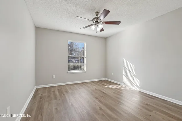 wooden floor in an empty room with a window