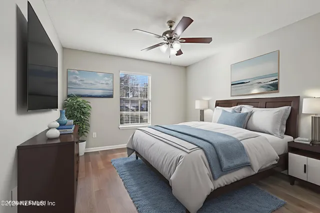 a bedroom with bed and a flat tv screen on dresser