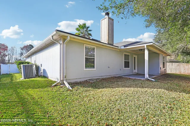 a backyard of a house with table and chairs