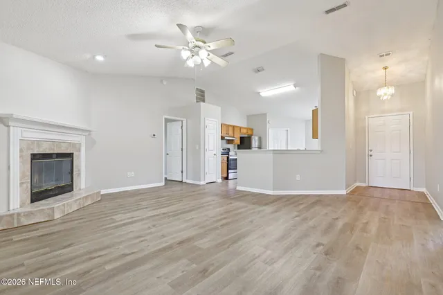 a view of empty room with wooden floor and fireplace