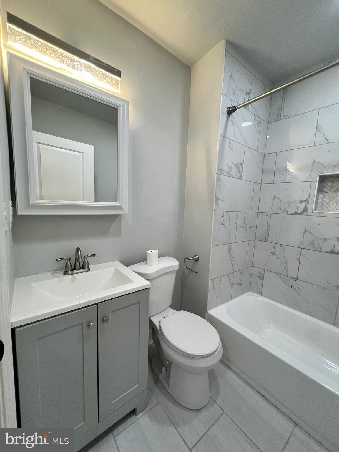1705 South 18th Street, Unit 1 Philadelphia, PA 19145 - Photo 13 of 18 a bathroom with a toilet a sink a mirror and bathtub