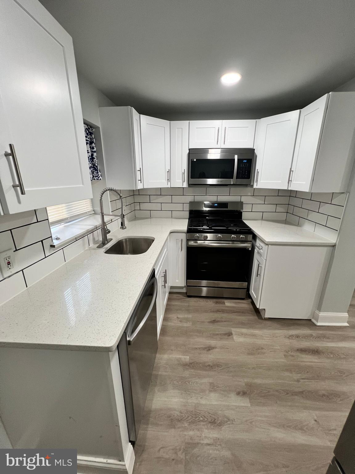 1705 South 18th Street, Unit 1 Philadelphia, PA 19145 - Photo 4 of 18 a kitchen with a sink a stove top oven and cabinetry