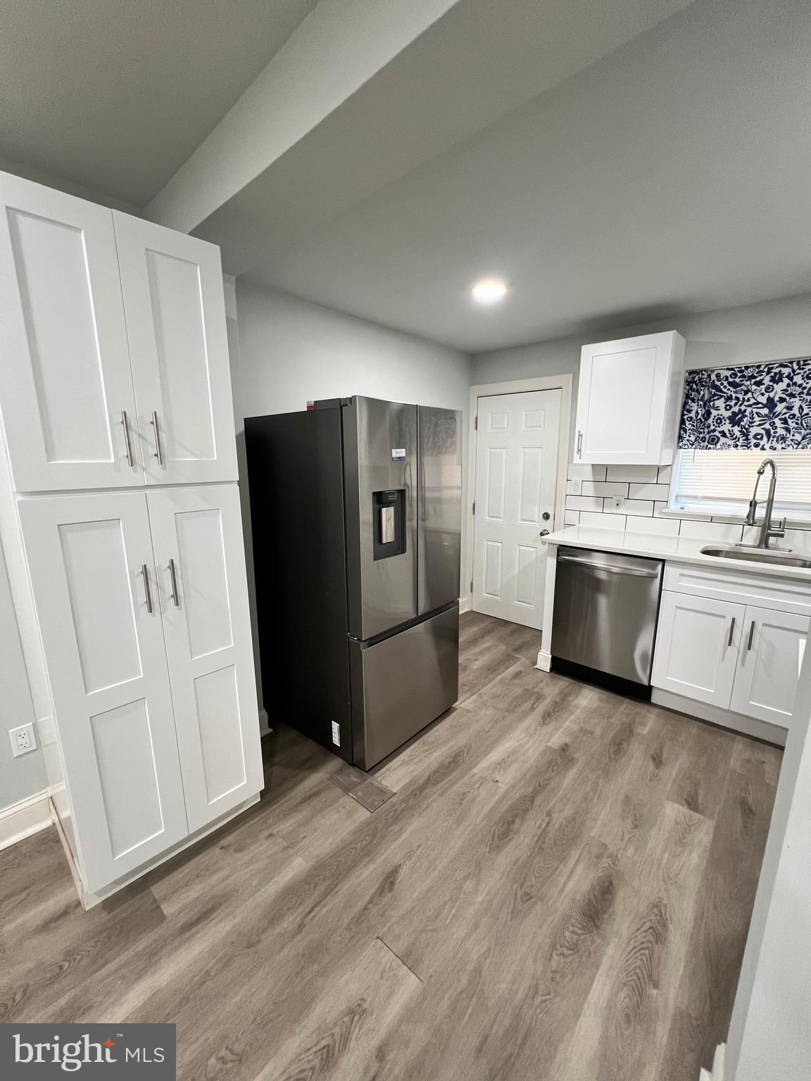 1705 South 18th Street, Unit 1 Philadelphia, PA 19145 - Photo 5 of 18 a kitchen with stainless steel appliances a refrigerator and wooden cabinets