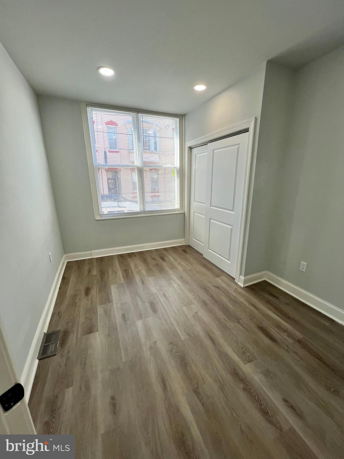 1705 South 18th Street, Unit 1 Philadelphia, PA 19145 - Photo 7 of 18 an empty room with wooden floor and windows