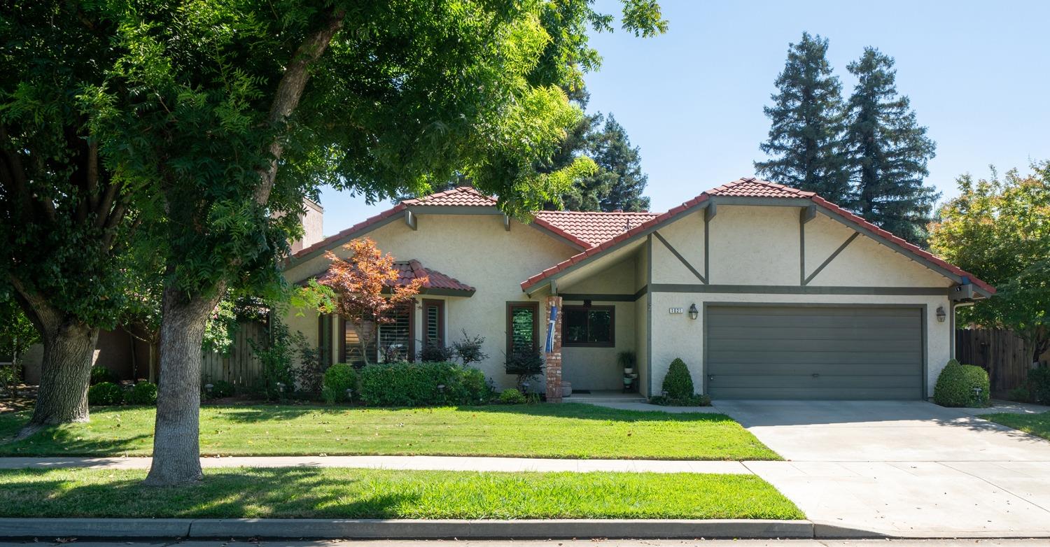 1021 Pistachio Avenue Clovis, CA 93611 - Photo 1 of 27 a white house with a small yard plants and large trees
