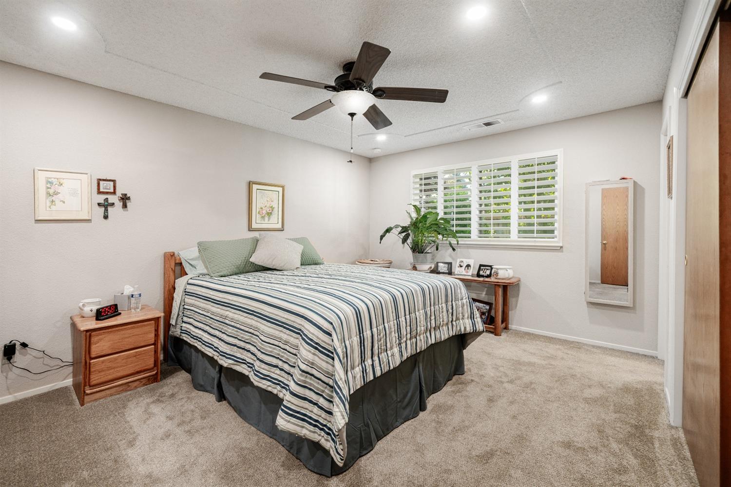 1021 Pistachio Avenue Clovis, CA 93611 - Photo 11 of 27 a spacious bedroom with a bed and a chandelier