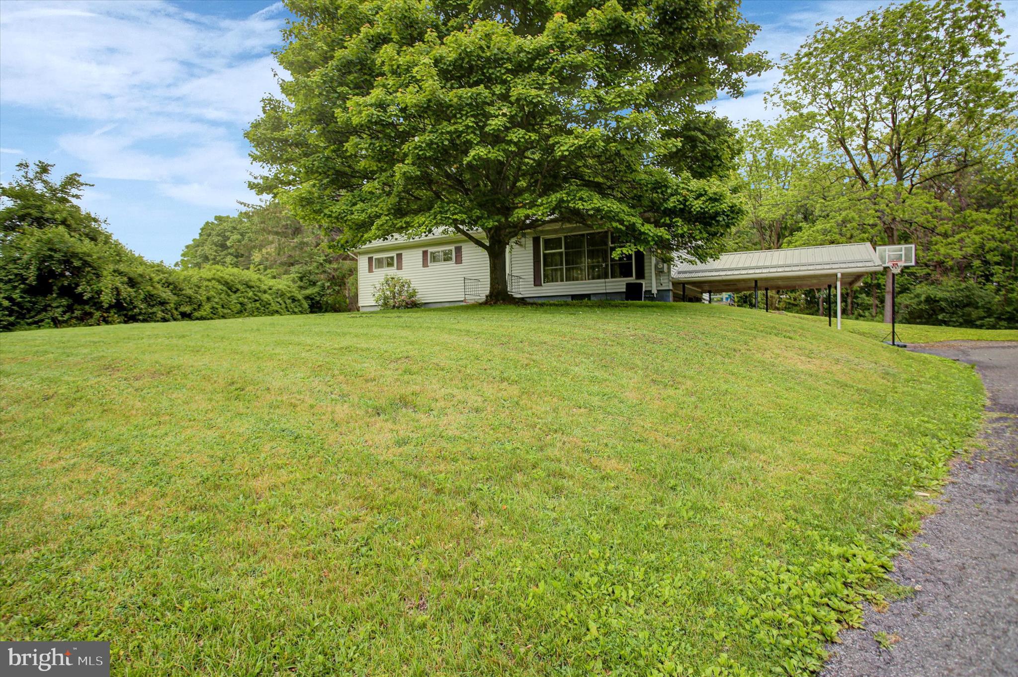 5156 Peach Orchard Road McConnellsburg, PA 17233 - Photo 3 of 34 a front view of a house with a garden