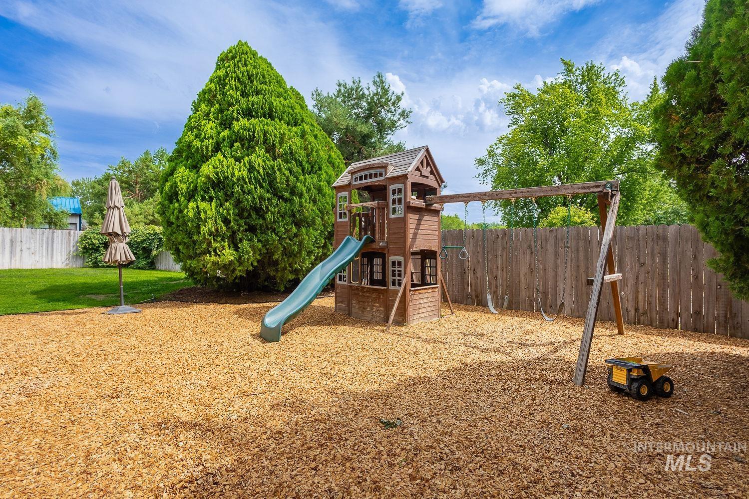 7166 South Cloverdale Road Boise, ID 83709 - Photo 24 of 50 Expansive green lawn, mature trees, covered patio, and additional outdoor space with wood chip ground cover