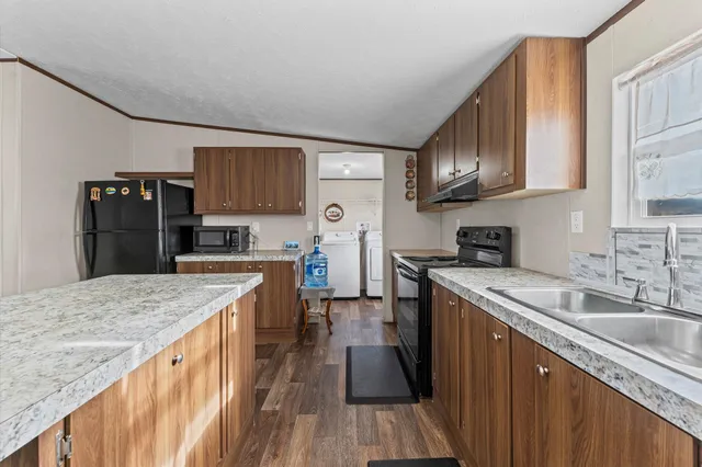 a kitchen with stainless steel appliances granite countertop a sink stove and refrigerator