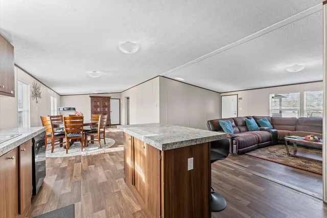 a living room with furniture a dining table and chairs with wooden floor