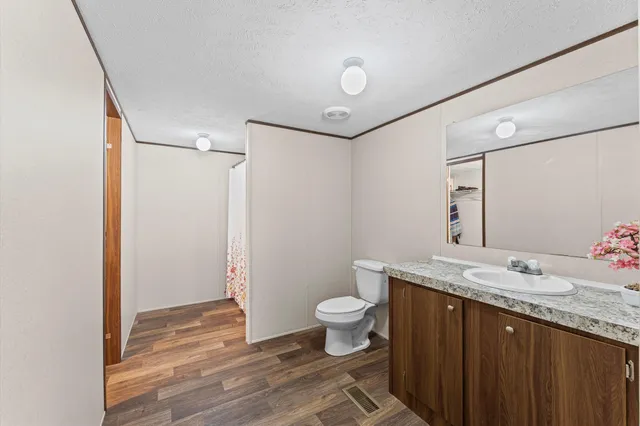 a bathroom with a granite countertop sink toilet and shower