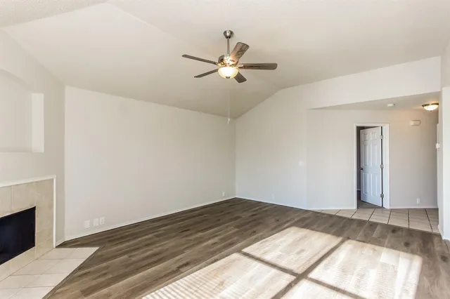 a view of a room with wooden floor and a ceiling fan