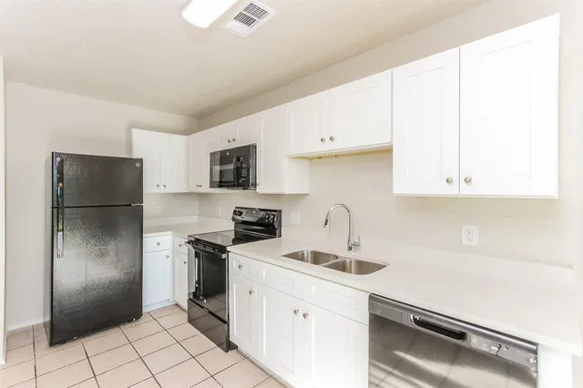 a kitchen with stainless steel appliances a refrigerator sink and cabinets