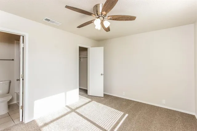 a view of a room with a ceiling fan and a bathroom