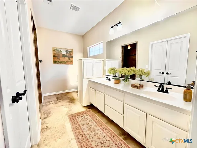 a bathroom with a double vanity sink mirror and