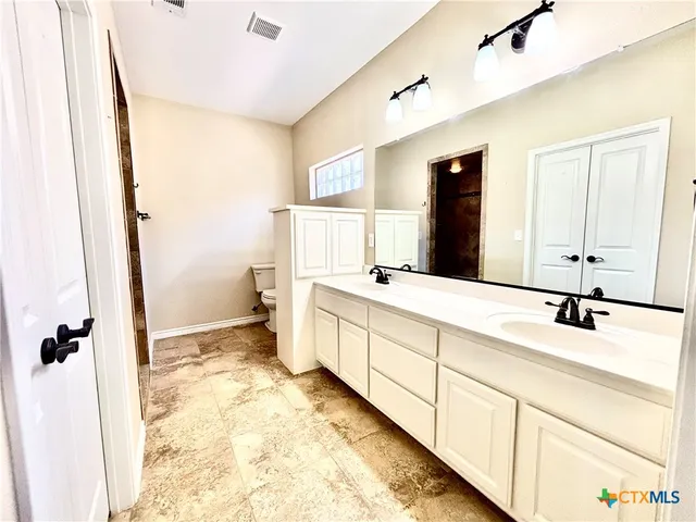 a bathroom with a double vanity sink and mirror