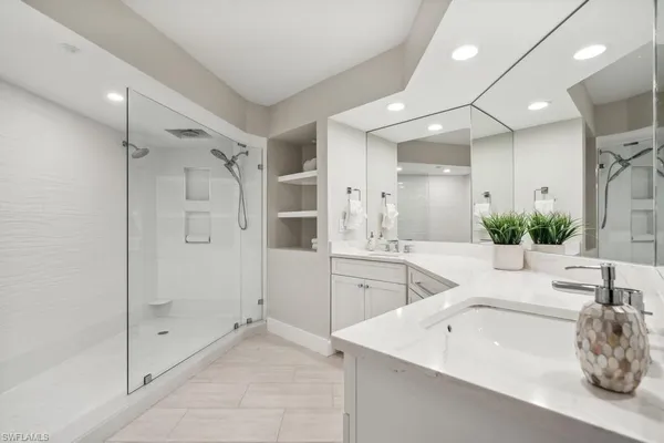 a spacious bathroom with a tub shower sink and mirror