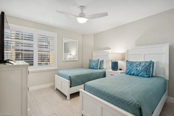 a bedroom with two beds and a large window