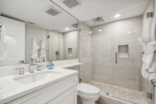 a bathroom with a sink a toilet and shower