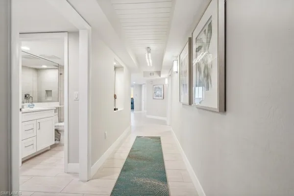 a view of a hallway with a cabinet and a mirror