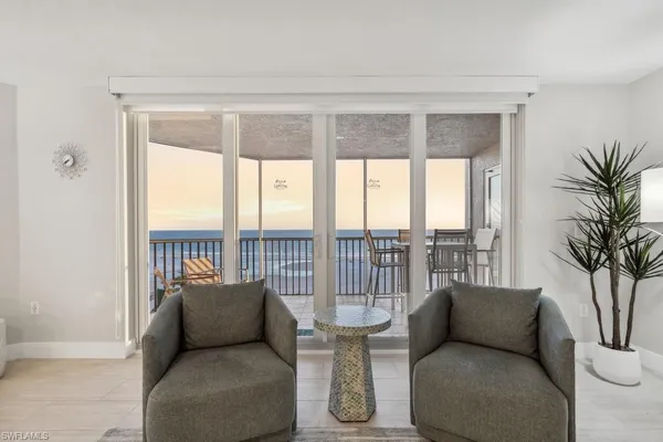 a living room with furniture and a floor to ceiling window