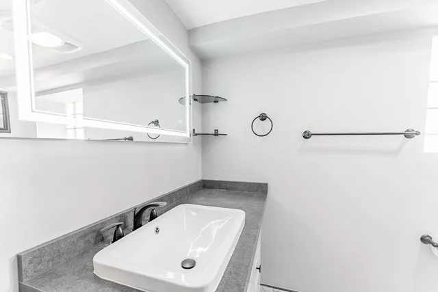 a bathroom with a sink a toilet and mirror