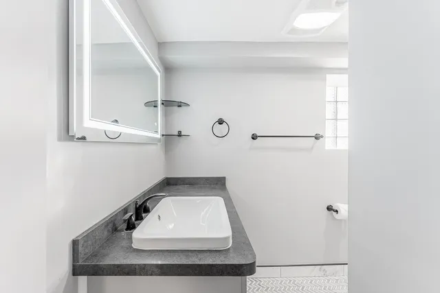 a bathroom with a sink toilet and mirror