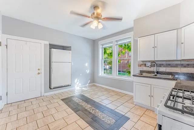 a open kitchen with white cabinets and window