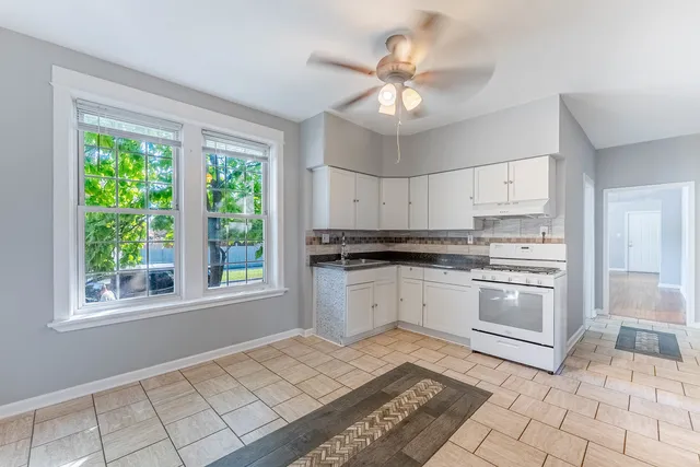 a kitchen with a stove a sink and cabinets