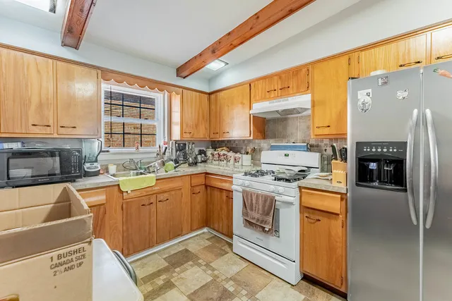 a kitchen with stainless steel appliances granite countertop a stove a sink dishwasher and a refrigerator