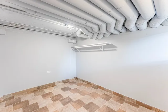 a view of a livingroom with a chandelier fan and wooden floor