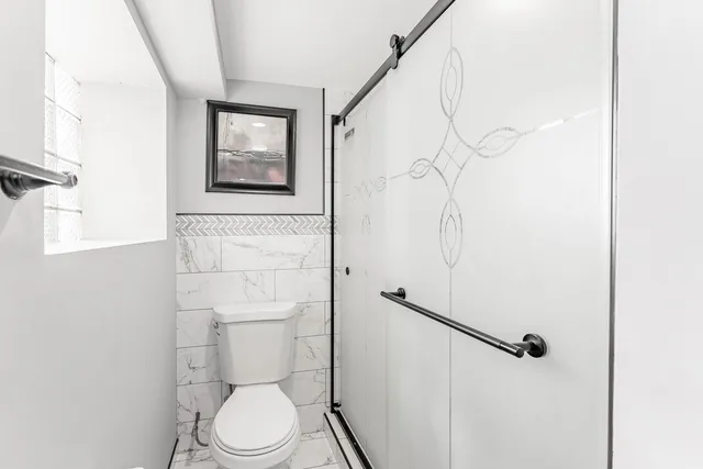 a white toilet sitting next to a bathroom sink