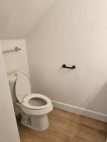 a white toilet sitting next to a wooden toilet