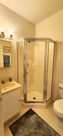 a bathroom with a sink a toilet a mirror and shower